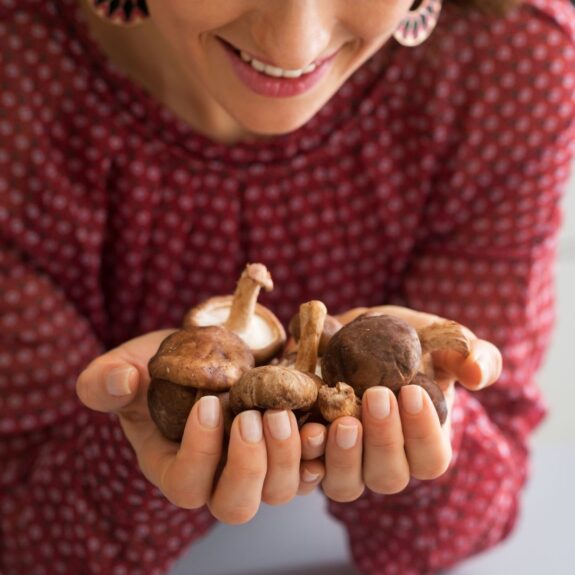 Person holding mushrooms and smiling